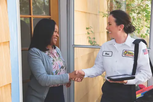 Nina, a Sarasota Mister Sparky electrician, greeting a homeowner with a handshake at the front door.